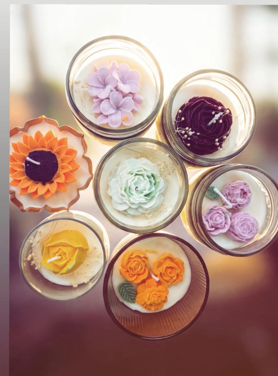 A colourful collection of flower candles arranged in glass vessels