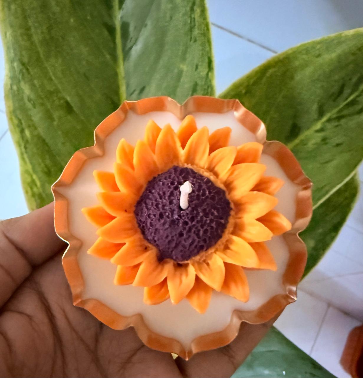 Sunflower-shaped candle held in one hand